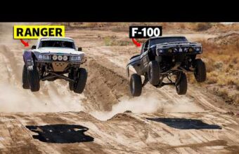 Two off-road trucks, labeled Ranger and F-100, are airborne over dirt mounds on a rugged terrain.