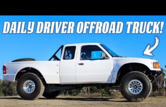 A white off-road truck with a Prerunner design parked on a dirt surface. The truck has large wheels, a roll cage, and a spare tire mounted in the bed. Text at the top says daily driver offroad truck.