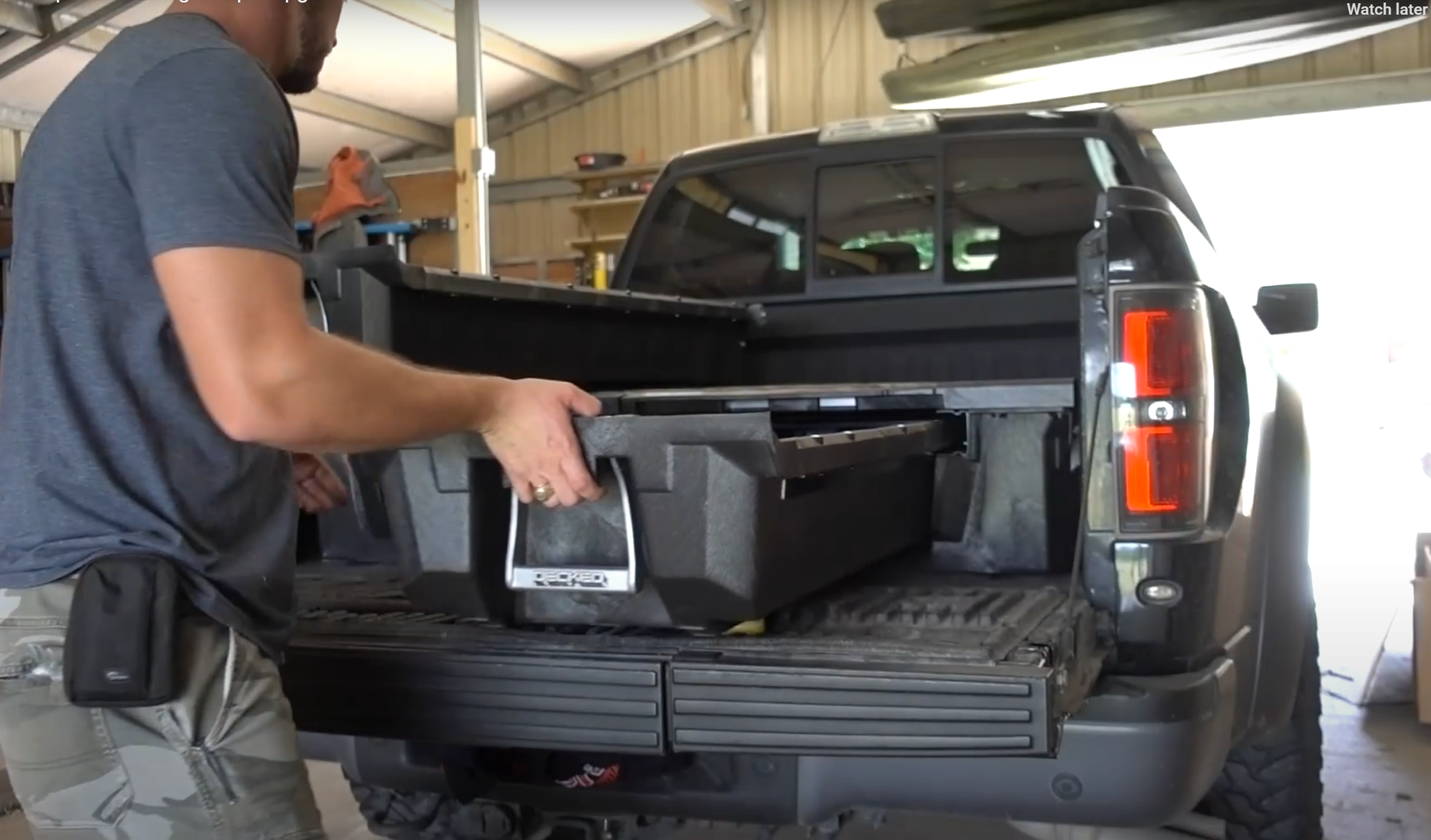 Man pulls out a Decked toolbox drawer from a black Ford Raptor